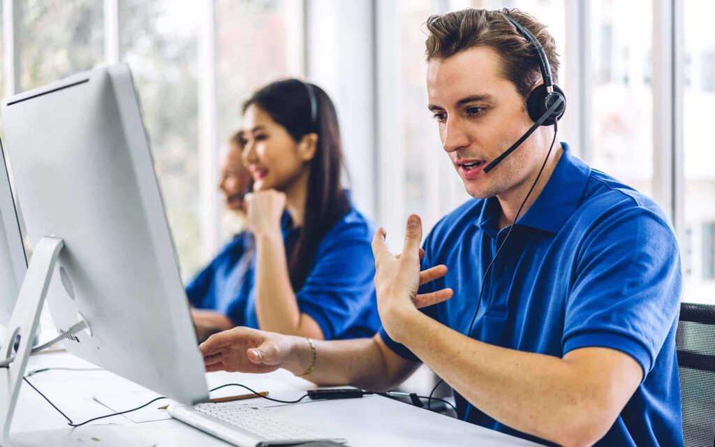 Group of happy call center smiling business operator customer support team phone services agen working and talking with headset on desktop computer at call center