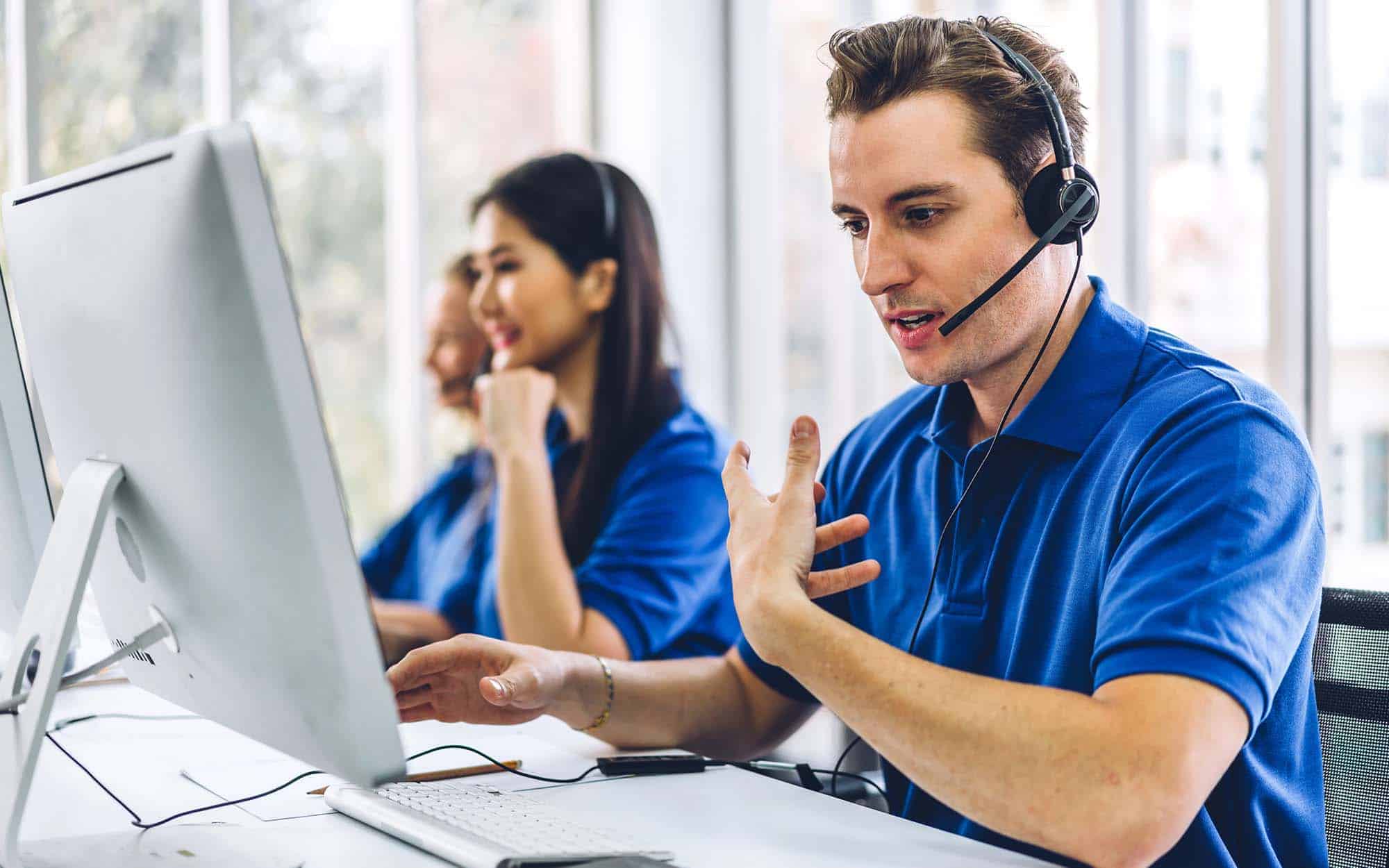 Group of happy call center smiling business operator customer support team phone services agen working and talking with headset on desktop computer at call center