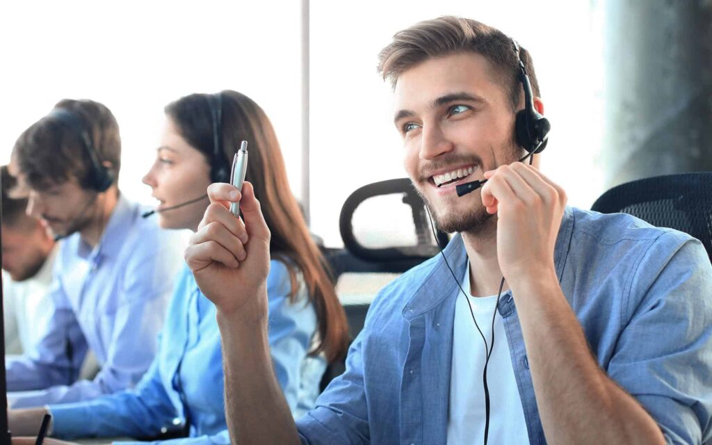 Image of a call center agent smiling on a phone call with a client.