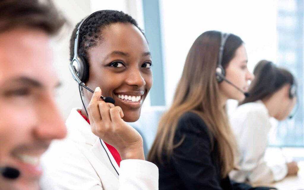 Image of a customer service person smiling on a call.