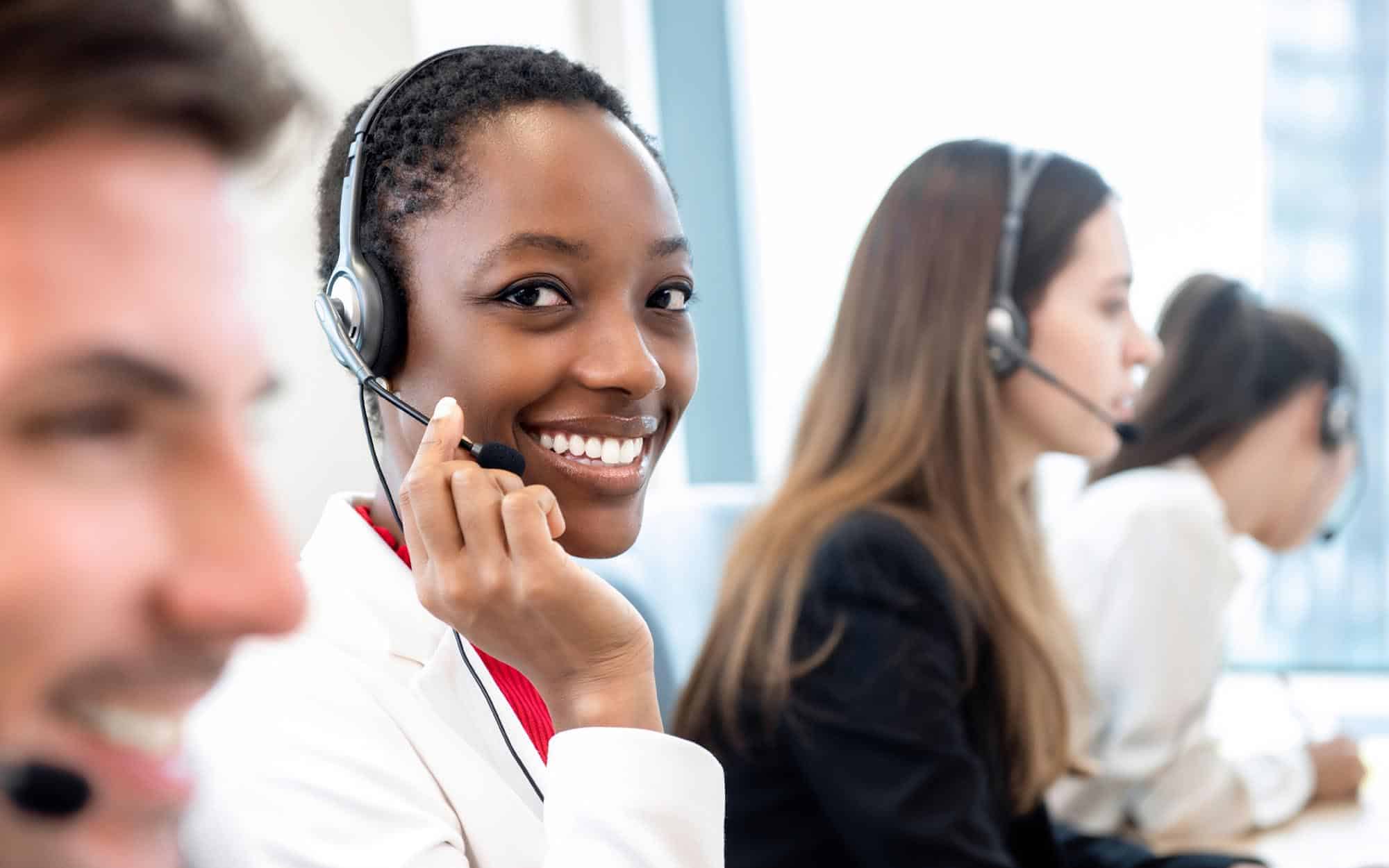 Image of a customer service person smiling on a call.