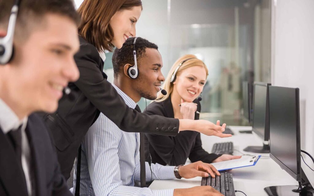 Image of a group of people assisting somebody in a call center.