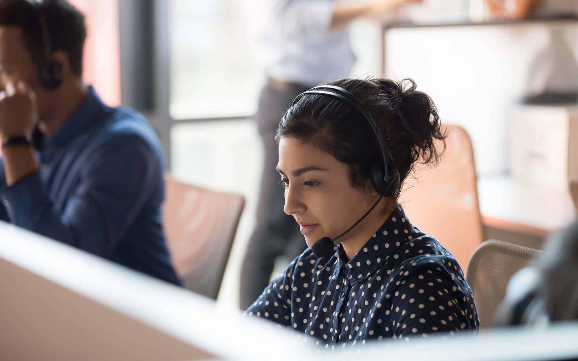 Indian call center agent wear headset work in customer support