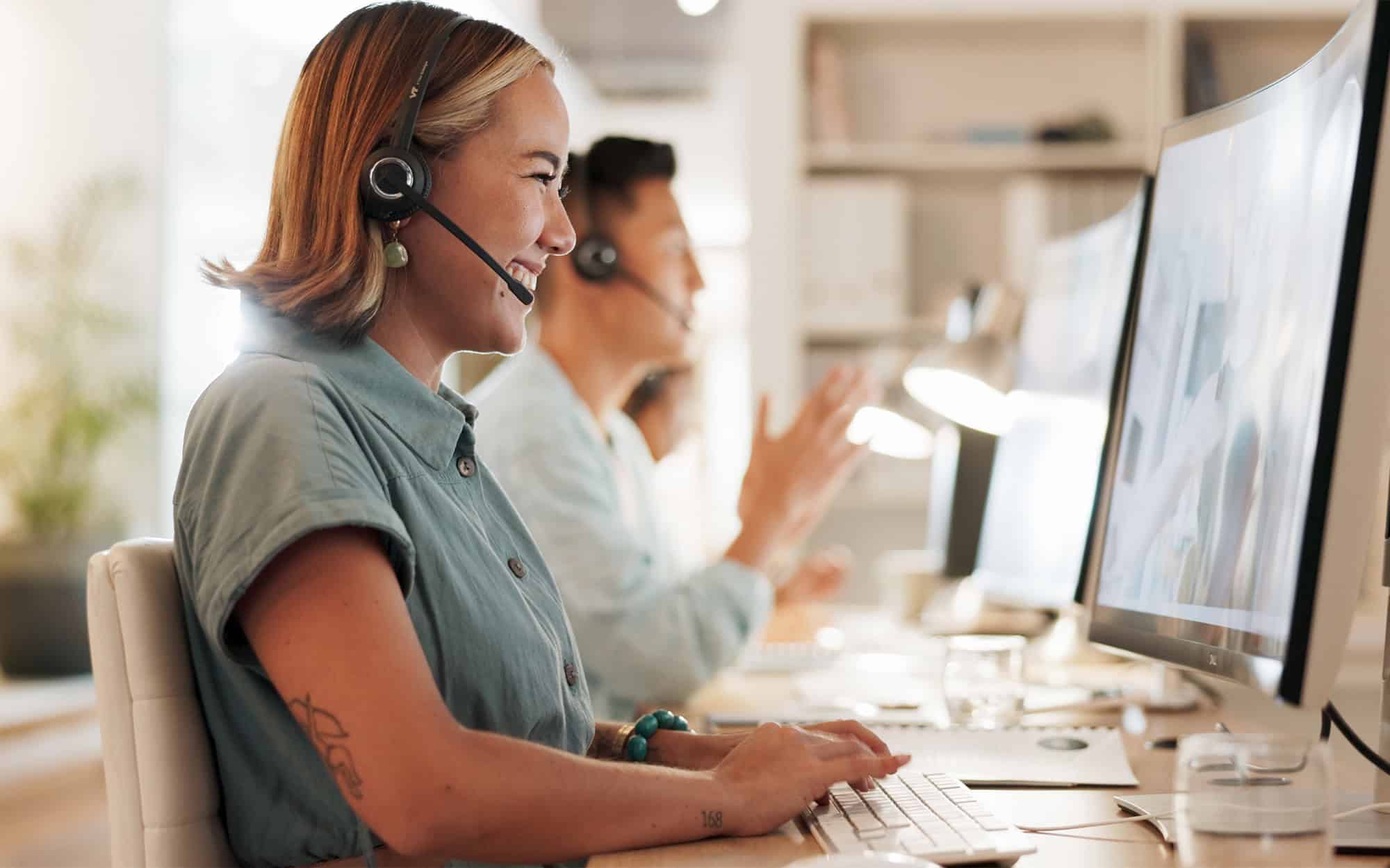 Side view of customer service representative smiling at her computer