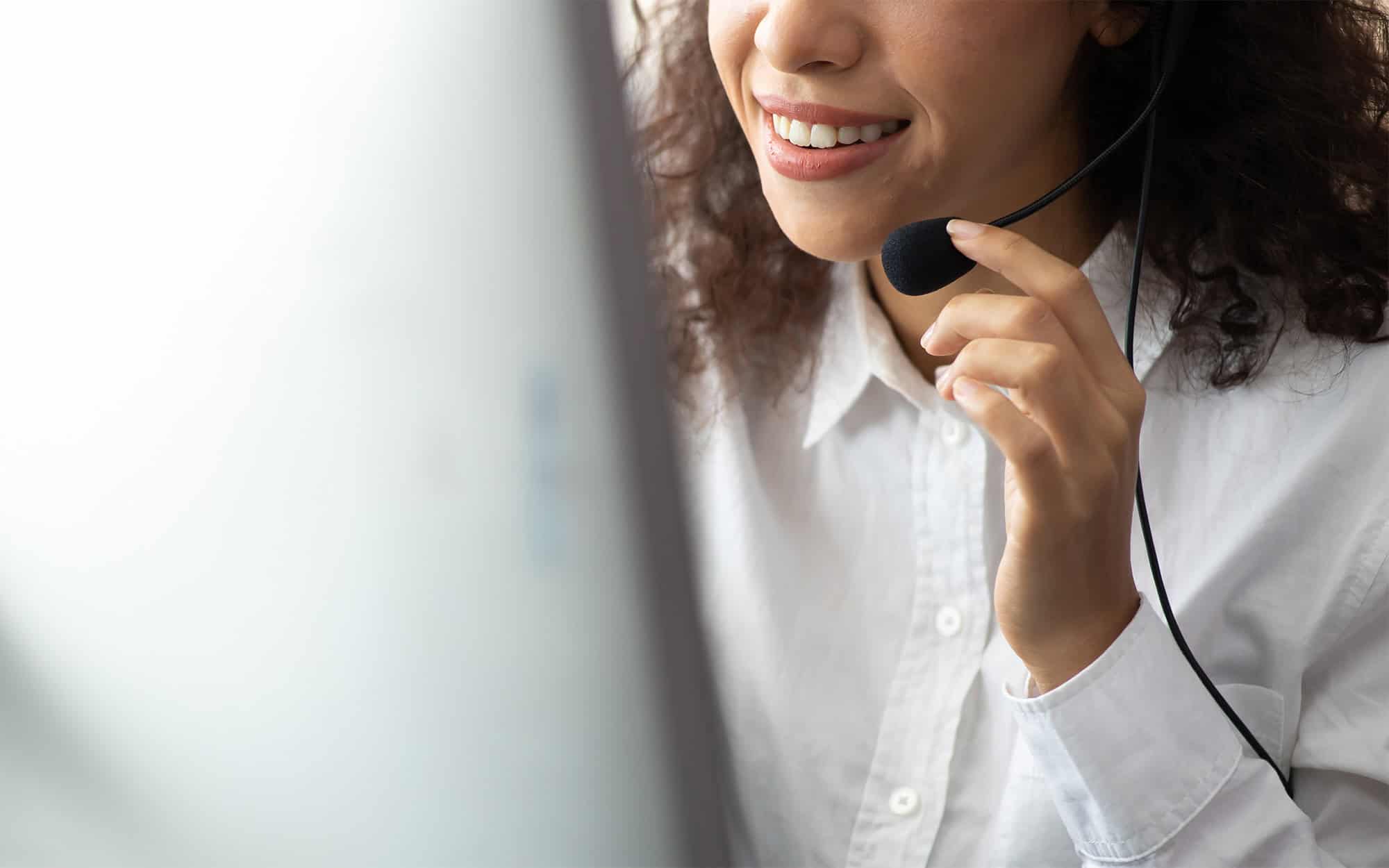 Side view of a woman with headset on talking into microphone